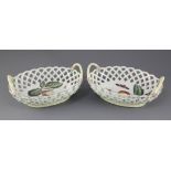 A pair of Derby polychrome pierced oval baskets, c.1760, each painted with fruit and insects to