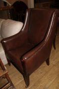 A brown leather wing back armchair