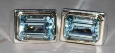 A pair of silver and blue topaz ear clips.