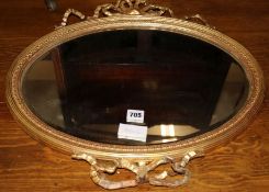 An oval gilt bevelled wall mirror, W.53cm (a.f.)