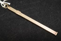An engine turned 9ct gold swizzle stick, 2.75in.