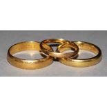 Three 22ct gold wedding bands.