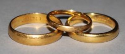 Three 22ct gold wedding bands.