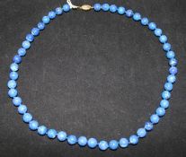 A single strand lapis lazuli bead necklace with 9ct gold clasp, 22in.