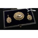 A Victorian 9ct gold oval brooch and matching pair of earring in fitted box.