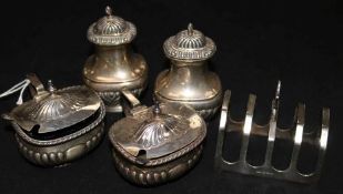Four silver condiments and a silver toast rack.