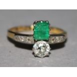 An 18ct gold and platinum, emerald and diamond crossover ring, with diamond set shoulders, size J.