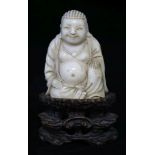 A Chinese ivory seated figure of Buddha, on a wood stand, 9cm