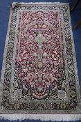 An Indian silk red ground rug