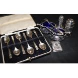 A pair of silver salts, a silver vesta, 2 silver peppers and silver spoons in case and tongs.