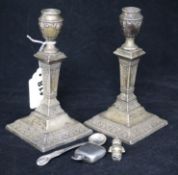 A pair of Edwardian silver candlesticks, sovereign case, rattle and condiment ladle.