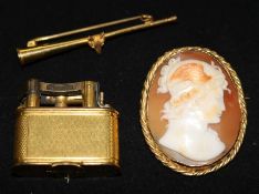 A 15ct gold hunting horn brooch, a cameo brooch and a Dunhill lighter.