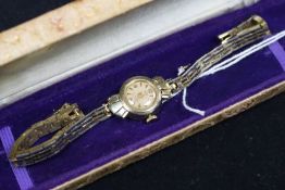 A lady's 14ct gold wrist watch, on a gilt metal bracelet.