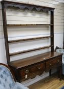An 18th century oak dresser, fitted two short drawers with plate rack over W.140cm