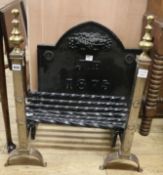 A wrought and cast iron fire grate, a fire back monogrammed J.P. and dated 1875, and a pair of brass