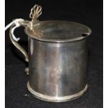 A George III silver drum shaped mustard pot, with pierced anthemion thumbpiece