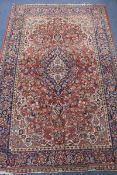 A Middle Eastern red and blue ground rug, 216cm x 139cm