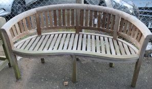 A modern teak bowed back garden bench, W.158cm