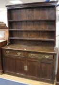 A mid 18th century oak dresser with open shelved rack, over drawers and cupboards, W.145cm