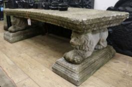 A reconstituted stone garden bench, on lion supports, W.175cm