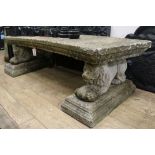 A reconstituted stone garden bench, on lion supports, W.175cm