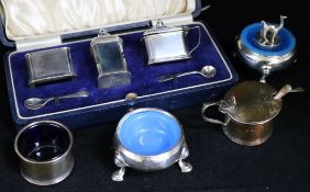 A cased silver three piece condiment set, two silver condiments, a silver stopper, two condiment