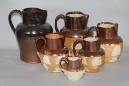 A graduated set of five Victorian earthenware hunting jugs and one other jug (6)