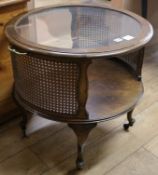 An oval mahogany framed two tier coffee table with plate glass top and caned sides, W.65cm