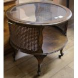 An oval mahogany framed two tier coffee table with plate glass top and caned sides, W.65cm