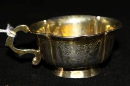 A late 18th century Russian silver gilt vodka cup, of cusped oval form with engraved foliate