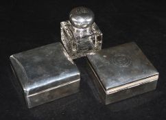 Two silver cigarette boxes and a silver mounted glass inkwell.