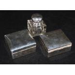 Two silver cigarette boxes and a silver mounted glass inkwell.