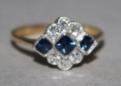 An Art Deco style 18ct gold, sapphire and diamond cluster ring, of lozenge shape, size P.