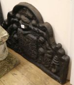 A 16th century style black painted cast iron fire back, W.90cm