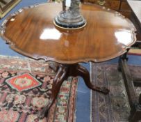 A George III mahogany circular topped supper table, on turned pillar and cabriole tripod base, the