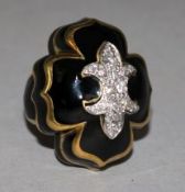 A yellow metal, black enamel and diamond set dress ring, of quatrefoil shape, with central motif set