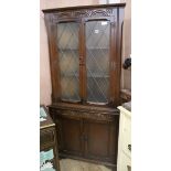 A carved oak glazed standing corner cupboard, H.178cm