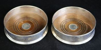 A pair of silver wine coasters with turned wooden bases, London, 1991, 5in.