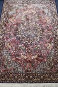 A Persian silk red ground floral medallion rug, 175cm x 122cm