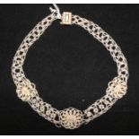 A 19th century seed pearl choker necklace with three flower head motifs and gold clasp set with