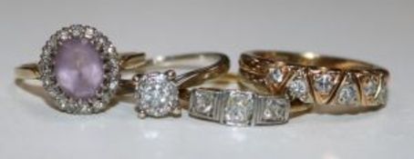 Four gold and gem set dress rings including three stone diamond and diamond half hoop.