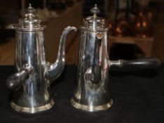 A pair of silver chocolate pots with ebonised handles and finials, Sheffield 1906, James Dixon &