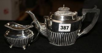 A demi fluted silver teapot and similar milk jug.
