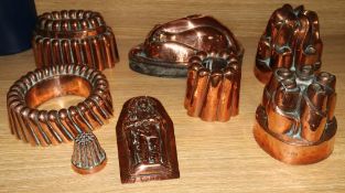 A collection of early copper jelly moulds and a later one