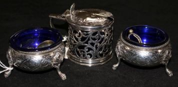 A Victorian pierced silver mustard, and a pair of cauldron salts, all with blue glass liners