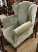 A green upholstered wing armchair