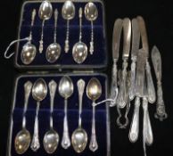 Six silver apostle teaspoons, another set of 12 teaspoons (both cased), 6 silver-handled butter