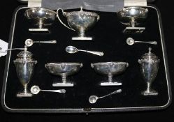 A cased matched seven piece silver condiment set by William Hutton & Sons.