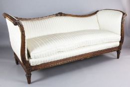 A Louis XVI style walnut serpentine settee, the show-wood frame carved with ribbon scrolls and