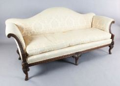 A Georgian style walnut three-seat settee, carved in relief with guilloche motifs, ram's heads and